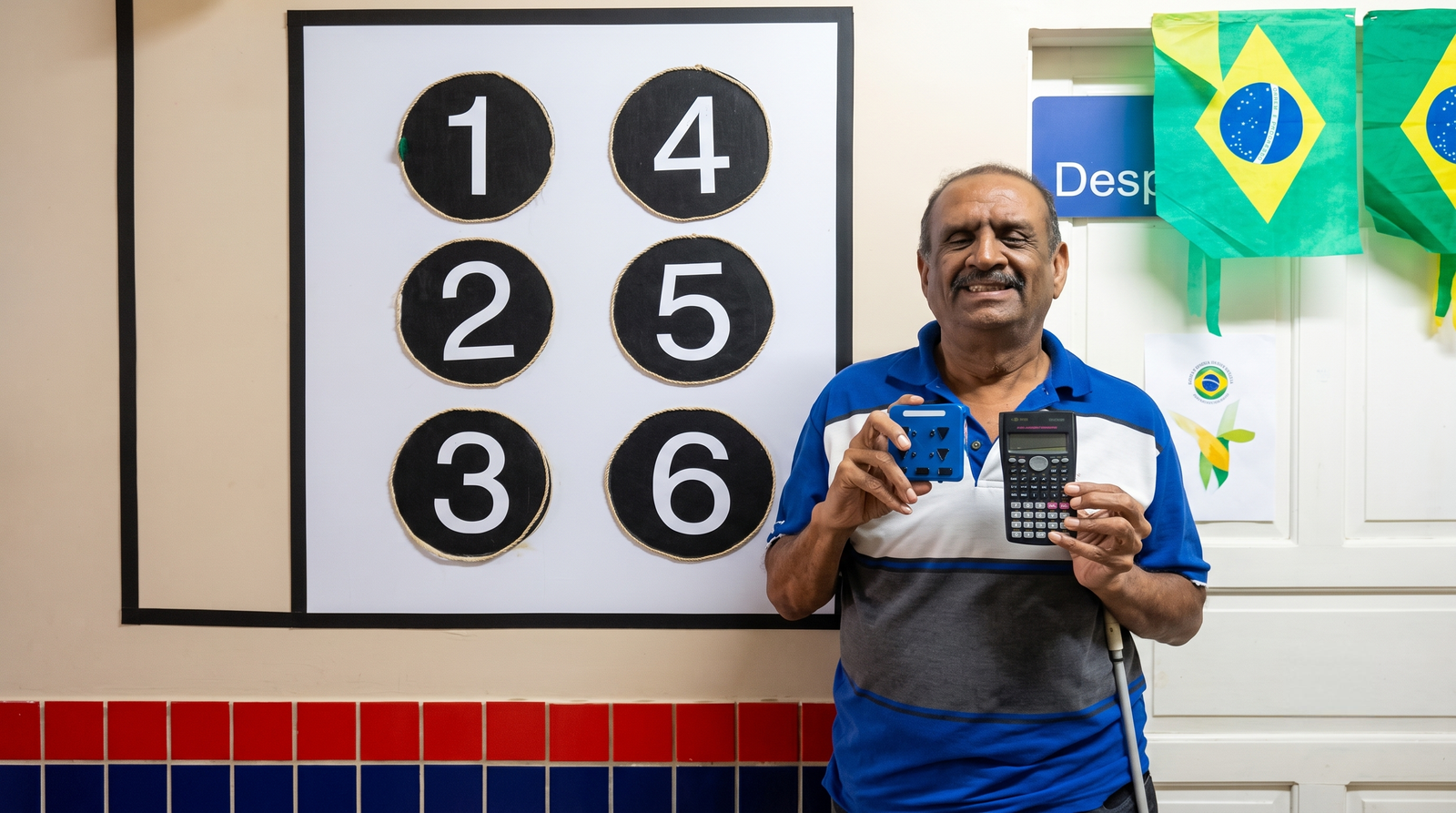 Alfredo Blanco sosteniendo en una mano la Calculadora MG40 de 4 botones y en la otra una calculadora científica convencional de 45 botones